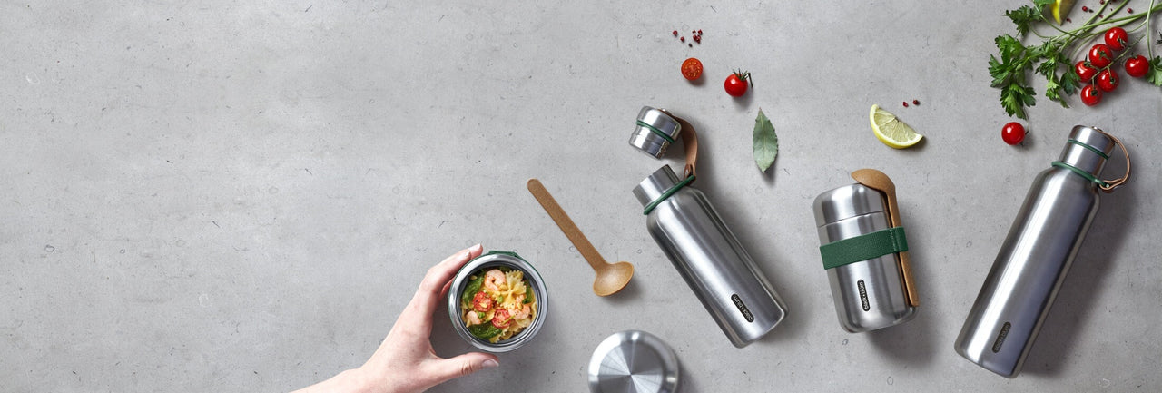 Insulated and leak proof thermos flasks on grey bench with food
